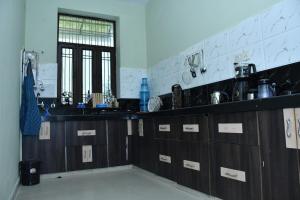 a kitchen with wooden cabinets and a sink at Happy Home in Jaipur +30 photos
