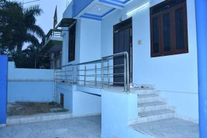a white house with stairs and a door at Happy Home in Jaipur
