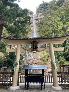 a blue bench in front of a waterfall at ゲストハウス両浜 in Kushimoto