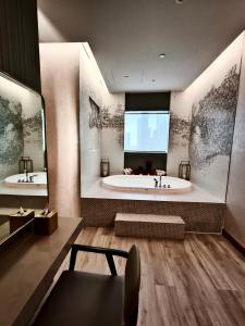 a large bathroom with a tub and a large window at Stunning 2BR with Burj View & Infinity Pool in Dubai