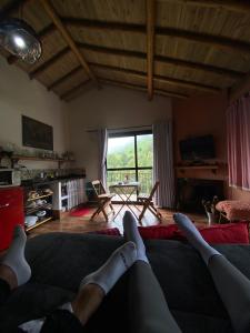 une personne assise sur un canapé dans un salon dans l'établissement Chalé Canto Mundo, à Brazópolis