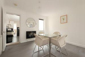 グレーズ・サロックにあるLovely 2 Bed Room House in Graysのダイニングルーム(ガラスのテーブル、椅子付)