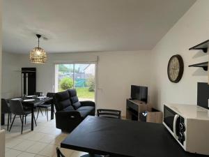 a living room with a table and a dining room at les tilleuls in Saint-Planchers