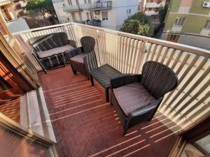 a balcony with three chairs and a table at Appartamento Marea in Grado