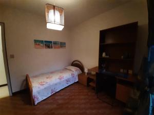 a small bedroom with a bed and a desk at Appartamento Marea in Grado