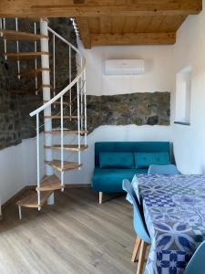 a bedroom with a blue couch and a spiral staircase at Casa Vanna in Carrodano Superiore +20 photos