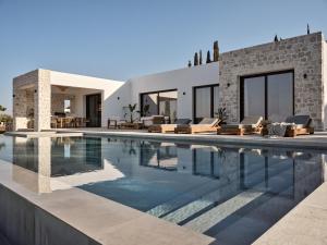 a swimming pool with chairs and a house at Zakynthos Villa with Stunning Views in Agios Nikolaos