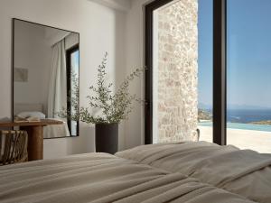 a bedroom with a bed and a mirror and a window at Zakynthos Villa with Stunning Views in Agios Nikolaos