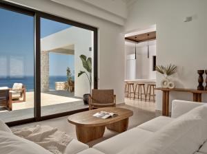 a living room with a white couch and a table at Zakynthos Villa with Stunning Views in Agios Nikolaos
