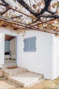 a white house with stairs and a window at Nona's House in Romanós