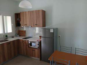 a kitchen with a stainless steel refrigerator and a table at Feeloxenia Corfu Apartments in Acharavi