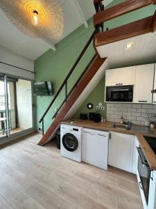 una cocina con lavadora y una escalera en La Mezza de Gruissan, en Gruissan