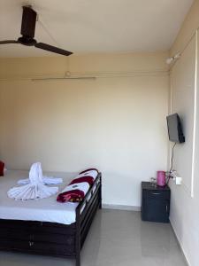 a bedroom with a bed and a flat screen tv at Lake view dining and Lodging in Lavasa