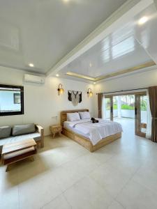 ein Schlafzimmer mit einem großen Bett und einer Couch in der Unterkunft Green Coco House in Amed