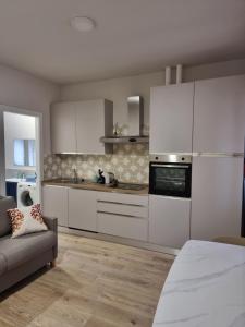 a kitchen with white cabinets and a couch in a room at Casa Candio in Pavia