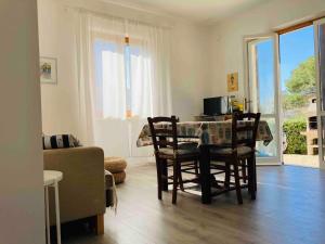 a living room with a table and chairs and a living room at Casa del Colle, con parcheggio privato sul mare! in Procchio +11 photos