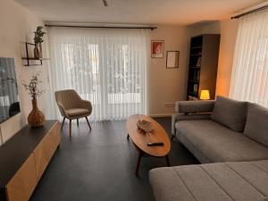 a living room with a couch and a table at Alpinelounge -modern - spacious in Waltenhofen