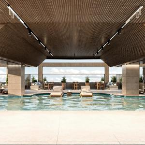 a lobby with a pool with chairs and tables at Radisson Hotel Jeddah Tahlia in Jeddah