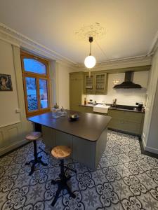 a large kitchen with a island in the middle at Maison d hotes villa les pervenches in La Chaux-de-Fonds