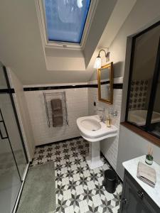 a bathroom with a sink and a toilet and a window at Maison d hotes villa les pervenches in La Chaux-de-Fonds
