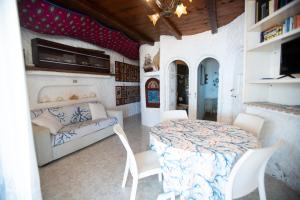 a room with a table and chairs and a couch at Villa a picco sul mare - Cala Creta in Lampedusa