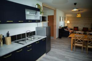 a kitchen and living room with a table and a dining room at Equi-Lodge in Parleboscq