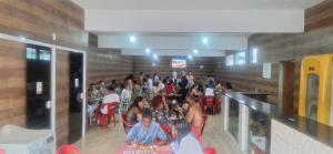 a large group of people sitting in a room at Pousada Malibu itaoca in Itapemirim