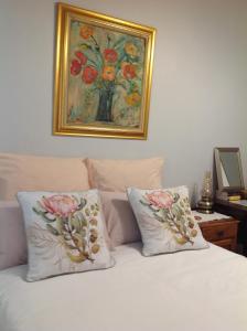 a bed with two pillows and a painting on the wall at The Pink Door in Caledon