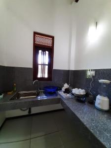 ヒッカドゥワにあるDream Home Holiday Stayのシンクと窓のあるキッチンカウンター +2枚の写真