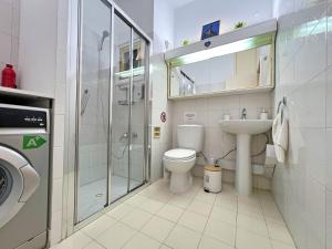 a bathroom with a toilet and a sink and a shower at Albert's Apartment Mackenzie 001 in Larnaka +11 photos