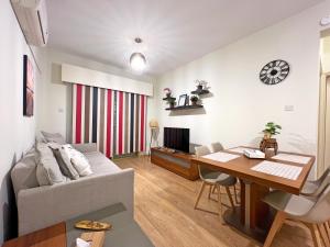 a living room with a couch and a wooden table at Albert's Apartment Mackenzie 001 in Larnaka