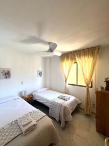 a bedroom with two beds and a ceiling fan at Relax Tropical in Almuñécar