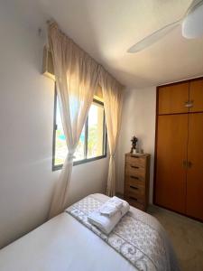 a bedroom with a bed and a window and a dresser at Relax Tropical in Almuñécar +7 photos
