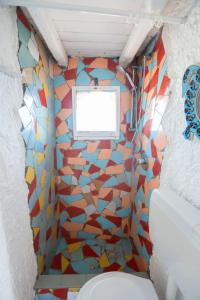 a bathroom with a toilet and a mosaic wall at Villa a picco sul mare - Cala Creta in Lampedusa +17 photos