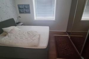 a white bed in a room with a window at Apartement in Drammen close to the main city in Drammen