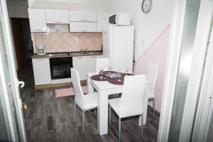 cocina con mesa blanca y sillas blancas en apartments VIGI - II, en Povljana 10 fotos más