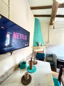 a living room with a table and a tv on a wall at Perla Azzurra - Forte dei Marmi - Cinque Terre in Montignoso