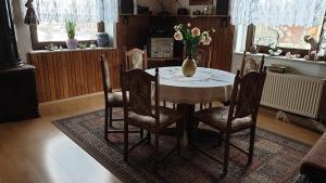 a dining room table with a vase of flowers on it at FW-Talblick in Annaberg-Buchholz +8 photos