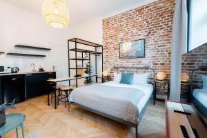Un dormitorio con una cama y una pared de ladrillo. en Boutique Apartments Possonium, en Bratislava