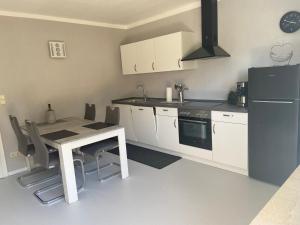 a kitchen with a table and a refrigerator at Ferienhaus Mayer Dahn Wohnung Neven in Dahn