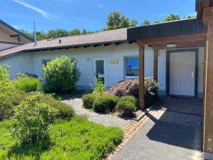 a house with a garage and a driveway at Ferienhaus Mayer Dahn Wohnung Neven in Dahn