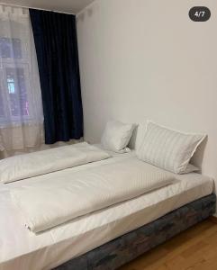 a bed with white sheets and pillows in a room at Ferien Wohnung in Chemnitz
