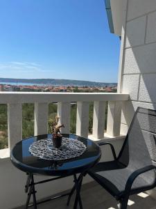 a table on a balcony with a potted plant on it at MAK apartment in Kaštela
