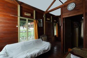 a bedroom with a bed and a clock on the wall at Villa Kayu Ciwidey in Bandung