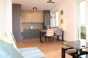 a kitchen and living room with a table and chairs at przytulny apartament in Mielec