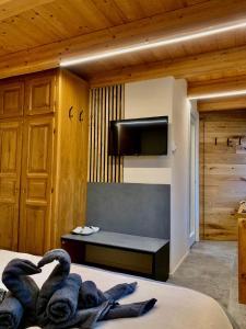 a bedroom with swans on a bed with a flat screen tv at Casa "Arvier" CIR n 0046 in Arvier +5 photos