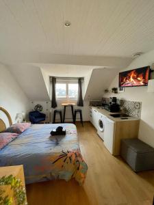 a bedroom with a bed and a kitchen in a attic at BLUE MOON in Saint-Nazaire