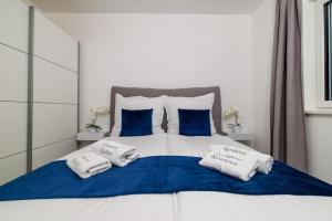 Una cama con almohadas azules y blancas. en Panorama Residence, en Crikvenica 35 fotos más