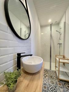 a bathroom with a large white tub and a mirror at BLUE MOON in Saint-Nazaire
