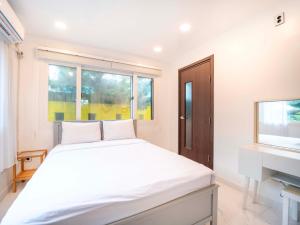 a white bedroom with a bed and a sink at Jeju Love Stay Yellow in Jeju +75 photos